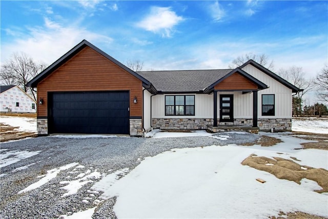 view of front of home with an attached garage, stone siding, and driveway