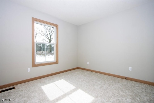 unfurnished room with carpet floors, visible vents, and baseboards