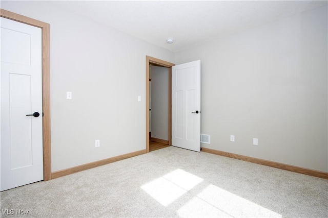 unfurnished bedroom with visible vents, baseboards, and carpet flooring