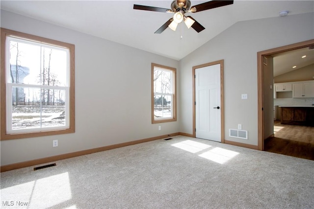 unfurnished bedroom featuring lofted ceiling, carpet floors, and visible vents