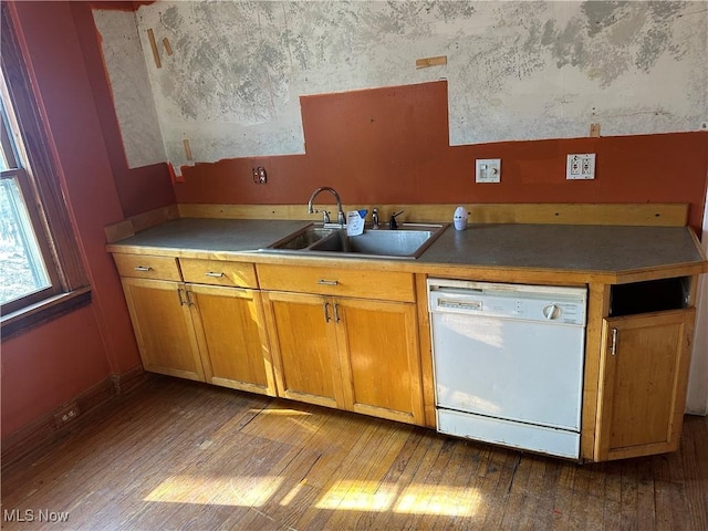 kitchen featuring dishwasher, brown cabinetry, light wood-type flooring, and a sink