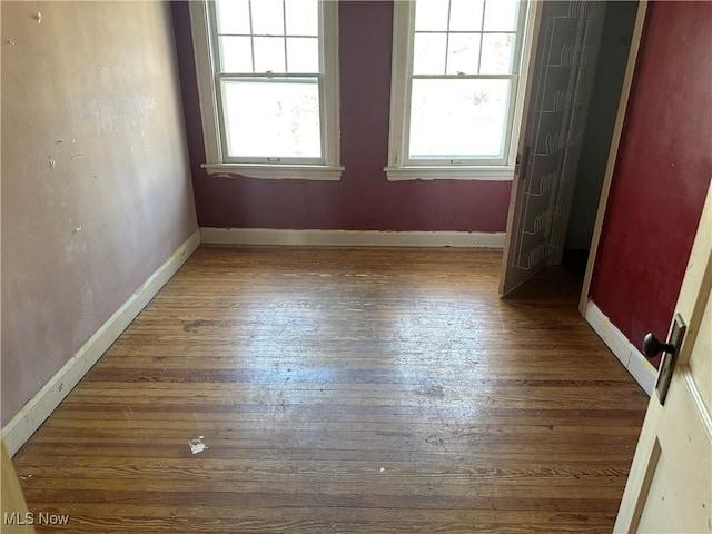 empty room featuring wood-type flooring and baseboards