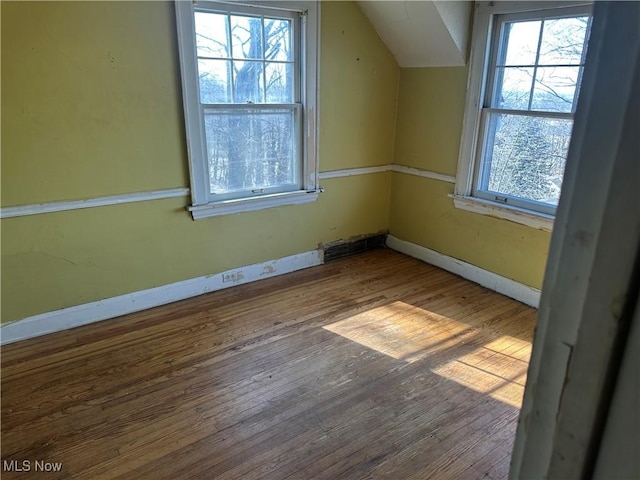 bonus room with visible vents, baseboards, vaulted ceiling, and wood finished floors