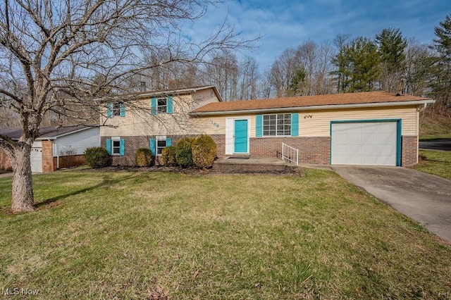 tri-level home featuring an attached garage, concrete driveway, brick siding, and a front yard