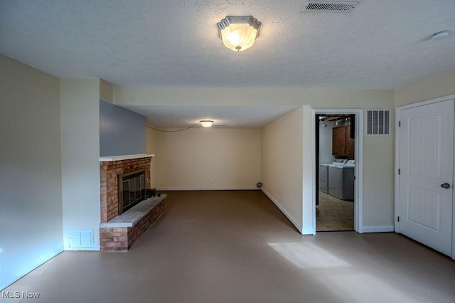 unfurnished living room with finished concrete flooring, washing machine and dryer, a fireplace, and visible vents