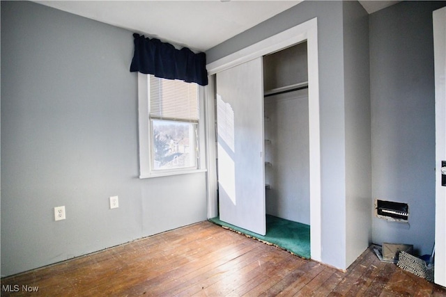 unfurnished bedroom featuring hardwood / wood-style floors and a closet