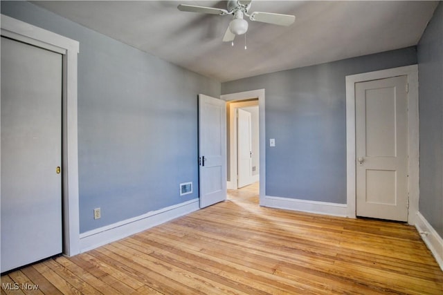 unfurnished bedroom featuring a ceiling fan, light wood-type flooring, visible vents, and baseboards