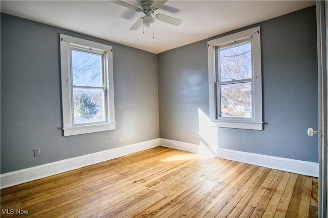 unfurnished room with a wealth of natural light, ceiling fan, light wood-style flooring, and baseboards