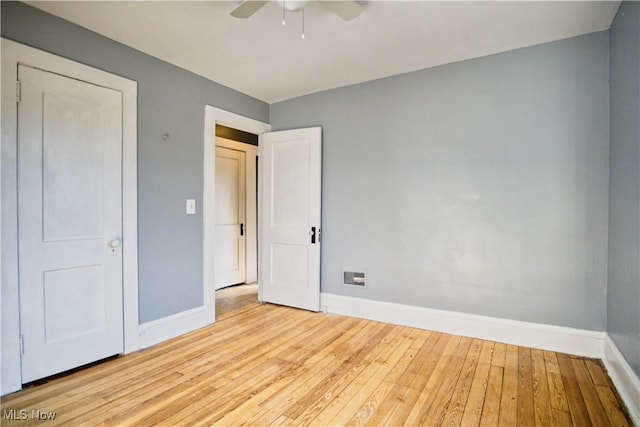 unfurnished bedroom featuring ceiling fan, hardwood / wood-style floors, and baseboards