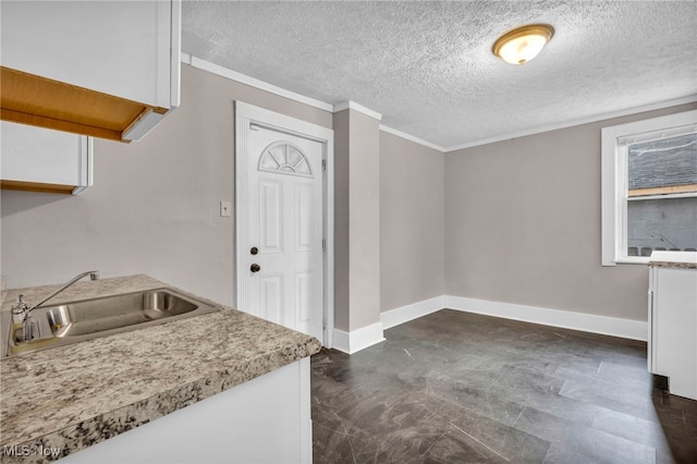 interior space with baseboards, a textured ceiling, and ornamental molding