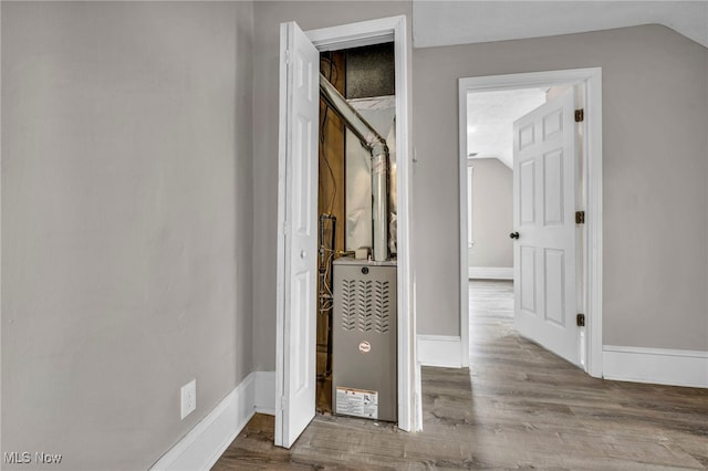 interior space featuring baseboards, vaulted ceiling, and wood finished floors