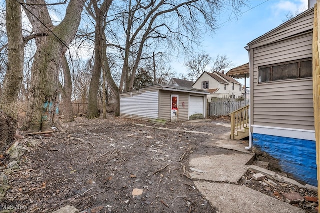 view of yard with an outdoor structure, fence, and a detached garage