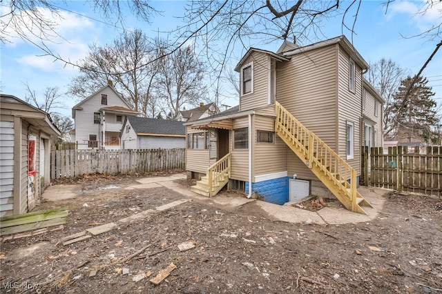 back of house featuring entry steps and fence