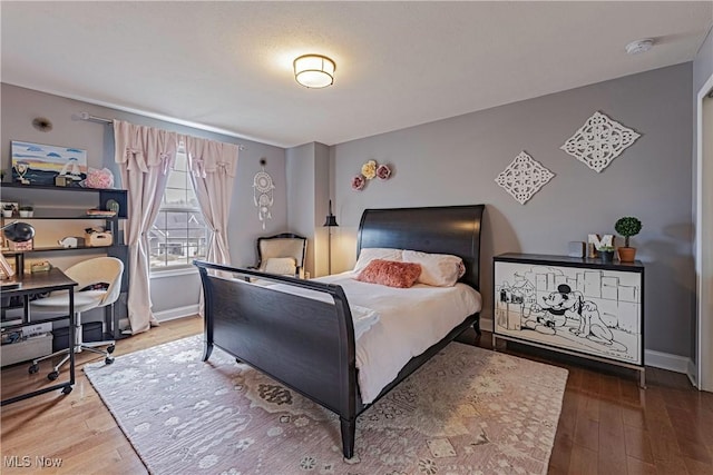 bedroom featuring hardwood / wood-style floors and baseboards