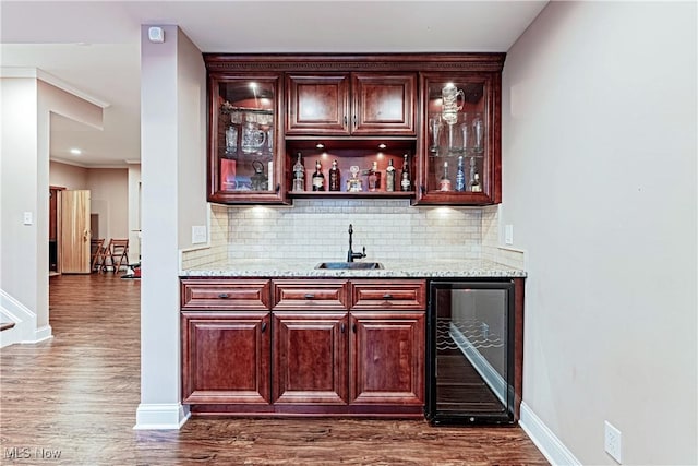 bar with wine cooler, dark wood-type flooring, a sink, and wet bar