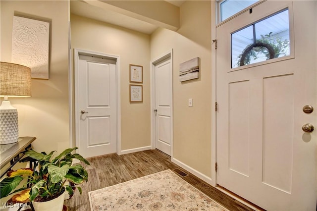 entrance foyer featuring baseboards and wood finished floors