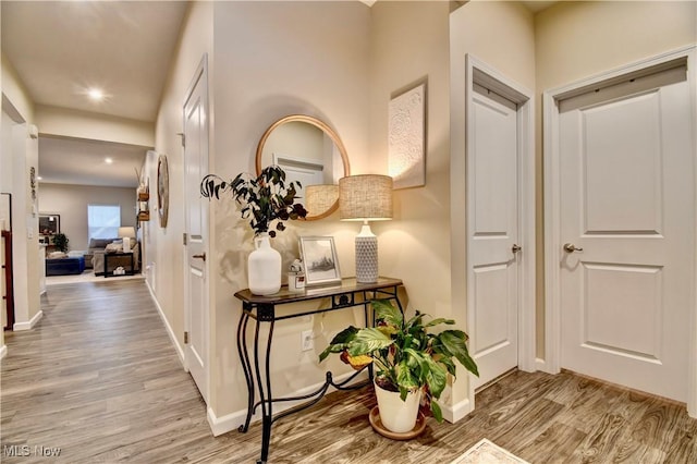 corridor featuring recessed lighting, baseboards, and wood finished floors