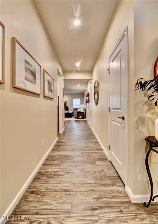 hallway with recessed lighting, baseboards, and wood finished floors