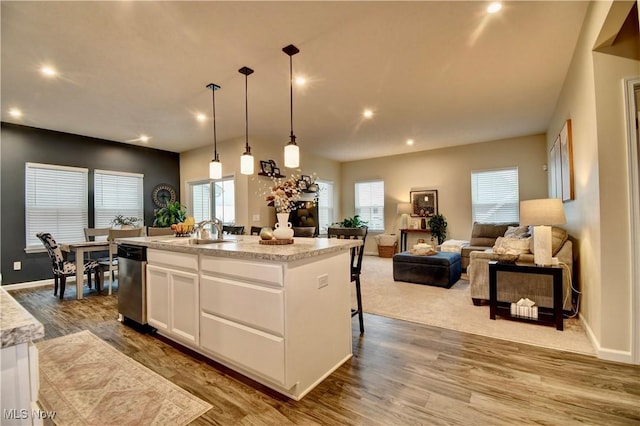 kitchen with dishwasher, dark wood-type flooring, white cabinets, and a sink