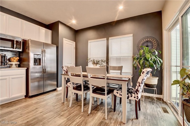 dining area featuring light wood-type flooring and baseboards