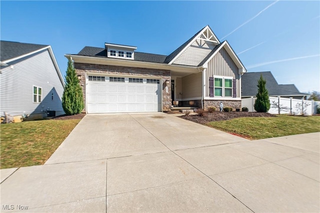 craftsman-style home with an attached garage, a front lawn, concrete driveway, stone siding, and board and batten siding