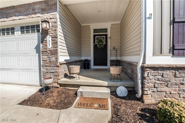 view of exterior entry featuring stone siding and an attached garage