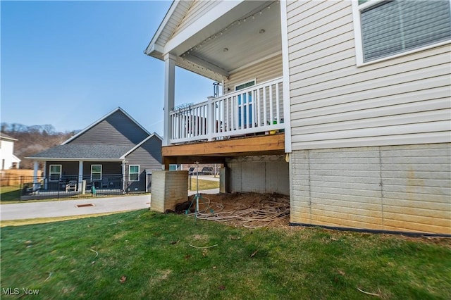 rear view of house with a yard, a deck, and fence