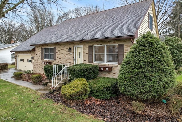 view of front of home featuring a shingled roof, brick siding, driveway, and an attached garage