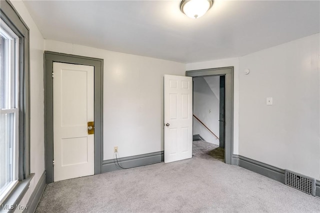 unfurnished room with carpet floors and visible vents