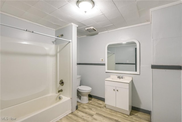 full bathroom with bathtub / shower combination, toilet, wood finished floors, visible vents, and vanity