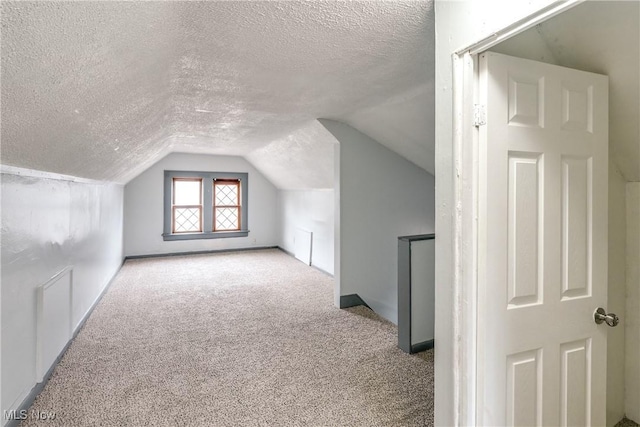 bonus room featuring carpet floors, vaulted ceiling, and a textured ceiling