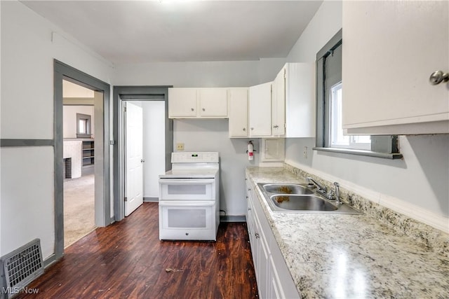 kitchen featuring light countertops, visible vents, white cabinetry, a sink, and double oven range