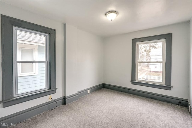 carpeted empty room with baseboards