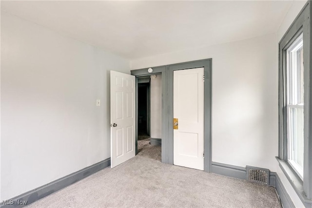 unfurnished bedroom with carpet flooring, visible vents, and baseboards