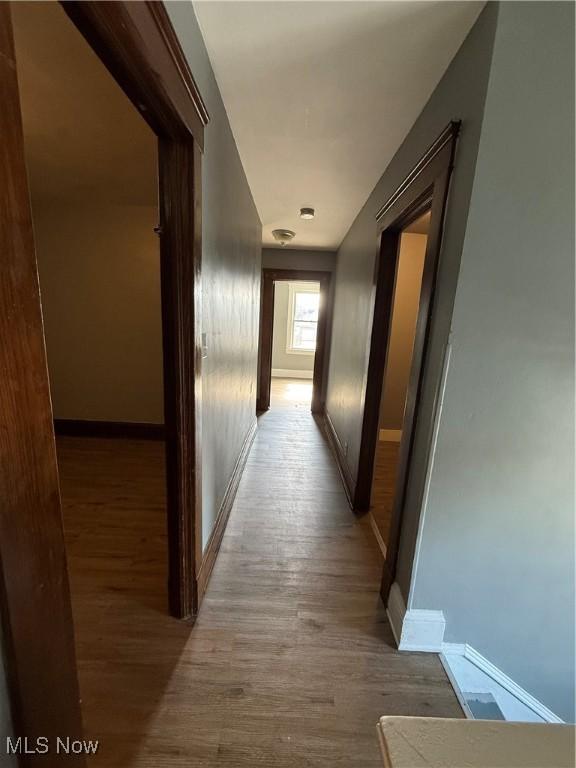 hallway with baseboards and wood finished floors