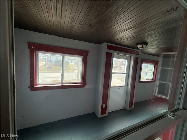 interior space featuring wooden ceiling and baseboards