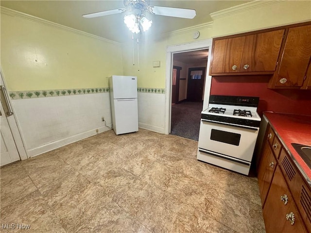 kitchen featuring white appliances, brown cabinetry, dark countertops, ornamental molding, and tile walls