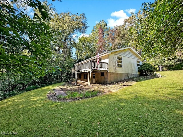 view of side of property featuring a yard and a wooden deck