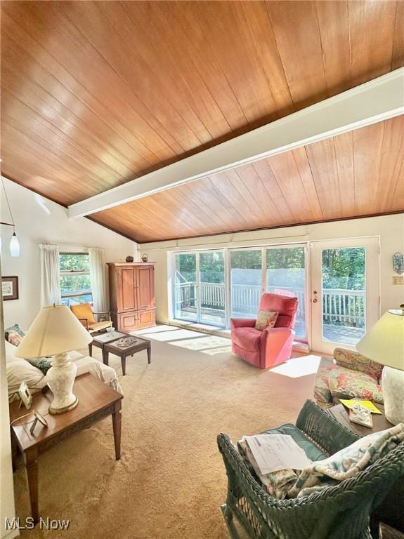 carpeted living room with lofted ceiling with beams and wooden ceiling