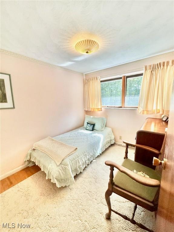 bedroom with baseboards and wood finished floors