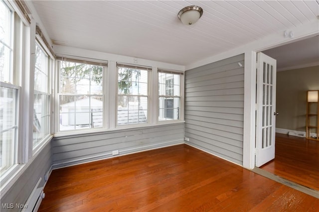 unfurnished sunroom with a wealth of natural light and a baseboard radiator