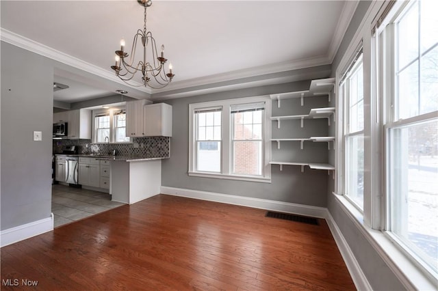 kitchen with appliances with stainless steel finishes, light wood-style floors, visible vents, and decorative backsplash