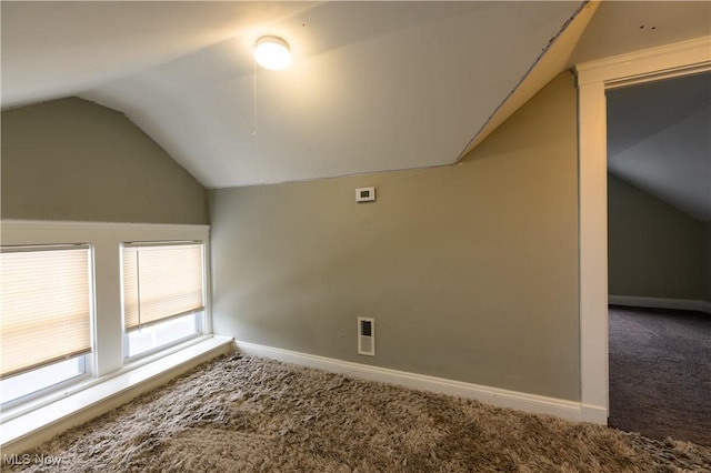 additional living space with lofted ceiling, carpet, visible vents, and baseboards