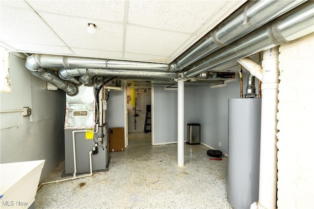 unfinished below grade area featuring water heater, a paneled ceiling, and heating unit