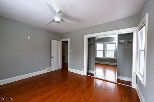 unfurnished bedroom featuring a ceiling fan, a closet, baseboards, and hardwood / wood-style floors