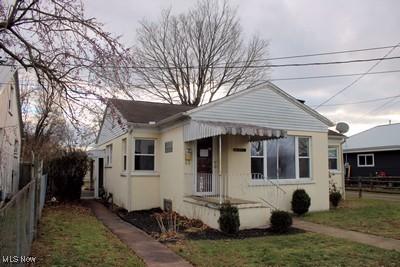 bungalow-style house featuring fence and a front lawn