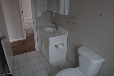 bathroom featuring tile patterned flooring, vanity, toilet, and baseboards