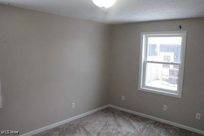 empty room featuring baseboards and carpet flooring