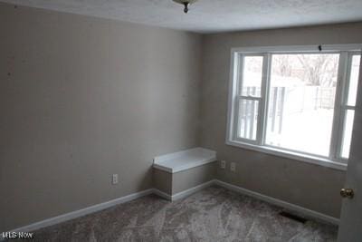 spare room with carpet, visible vents, and baseboards