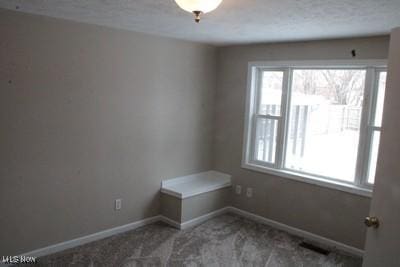 unfurnished room featuring carpet and baseboards